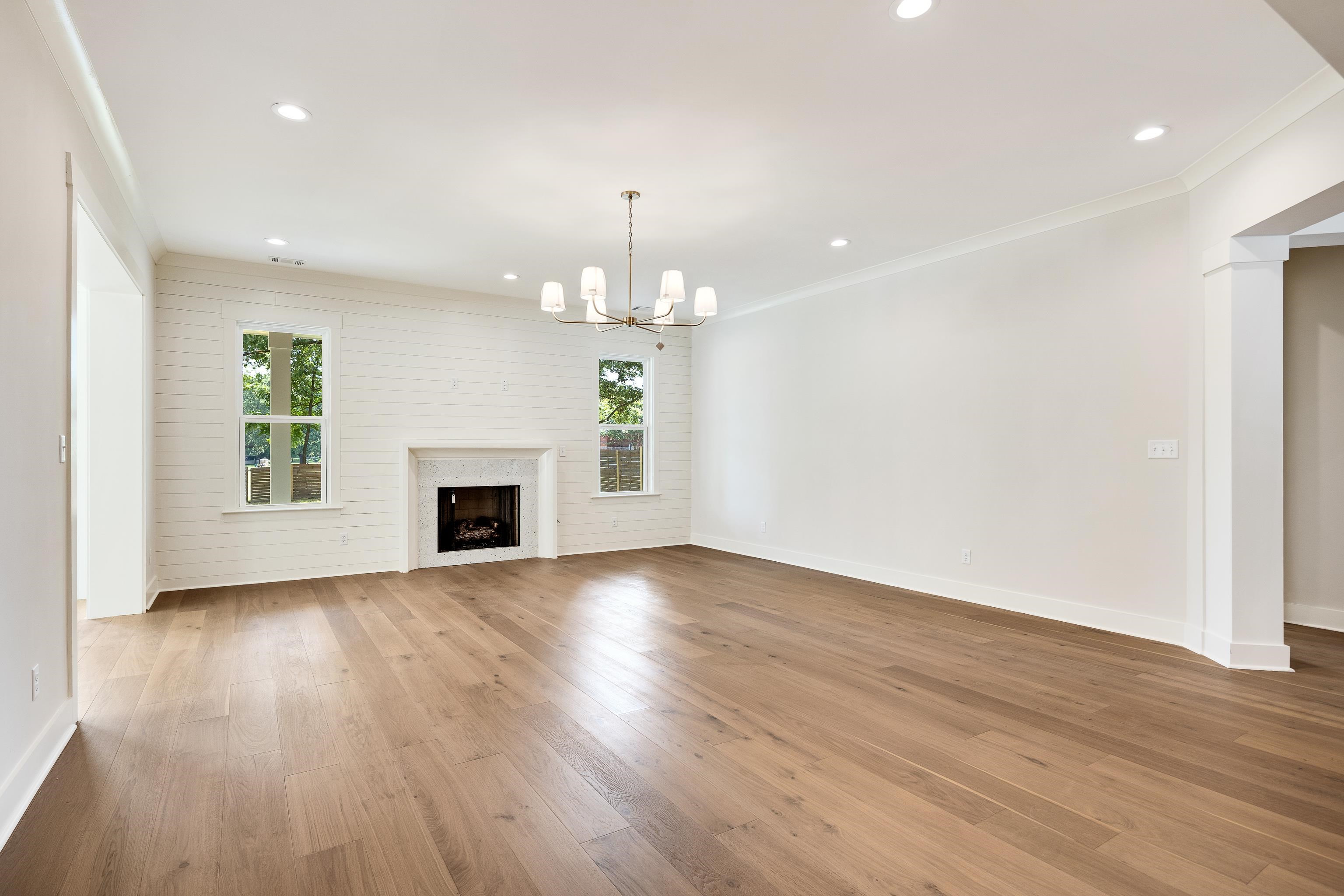 352 Avon Road Memphis, TN 38117 - Photo 6 of 26 Unfurnished living room featuring light wood-style floors, recessed lighting, a high end fireplace, a chandelier, and ornamental molding