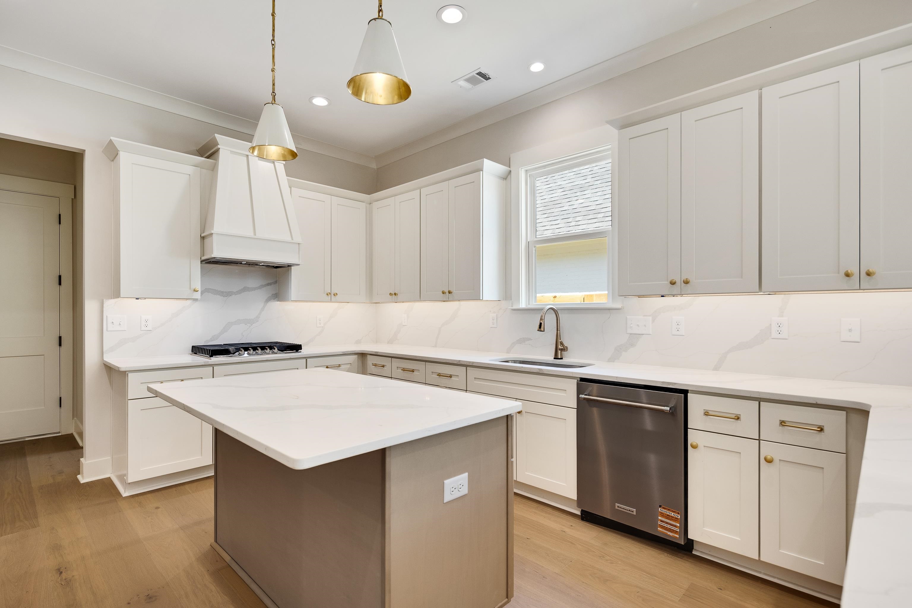 352 Avon Road Memphis, TN 38117 - Photo 9 of 26 Kitchen featuring dishwasher, hanging light fixtures, light stone counters, ornamental molding, and white cabinetry