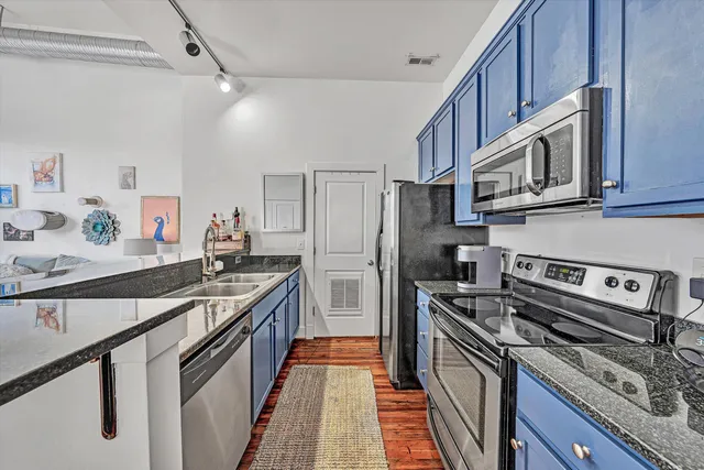 a kitchen with stainless steel appliances granite countertop a refrigerator stove and cabinets