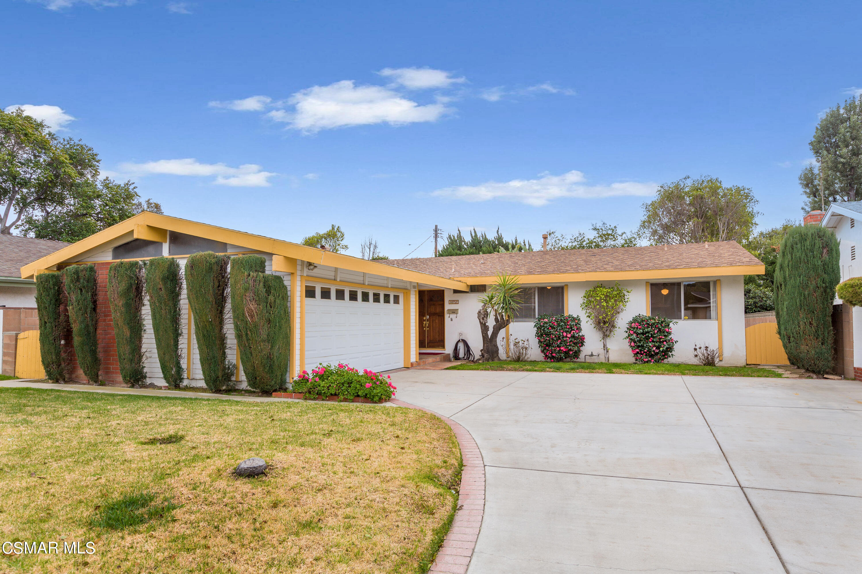 a front view of a house with a garden