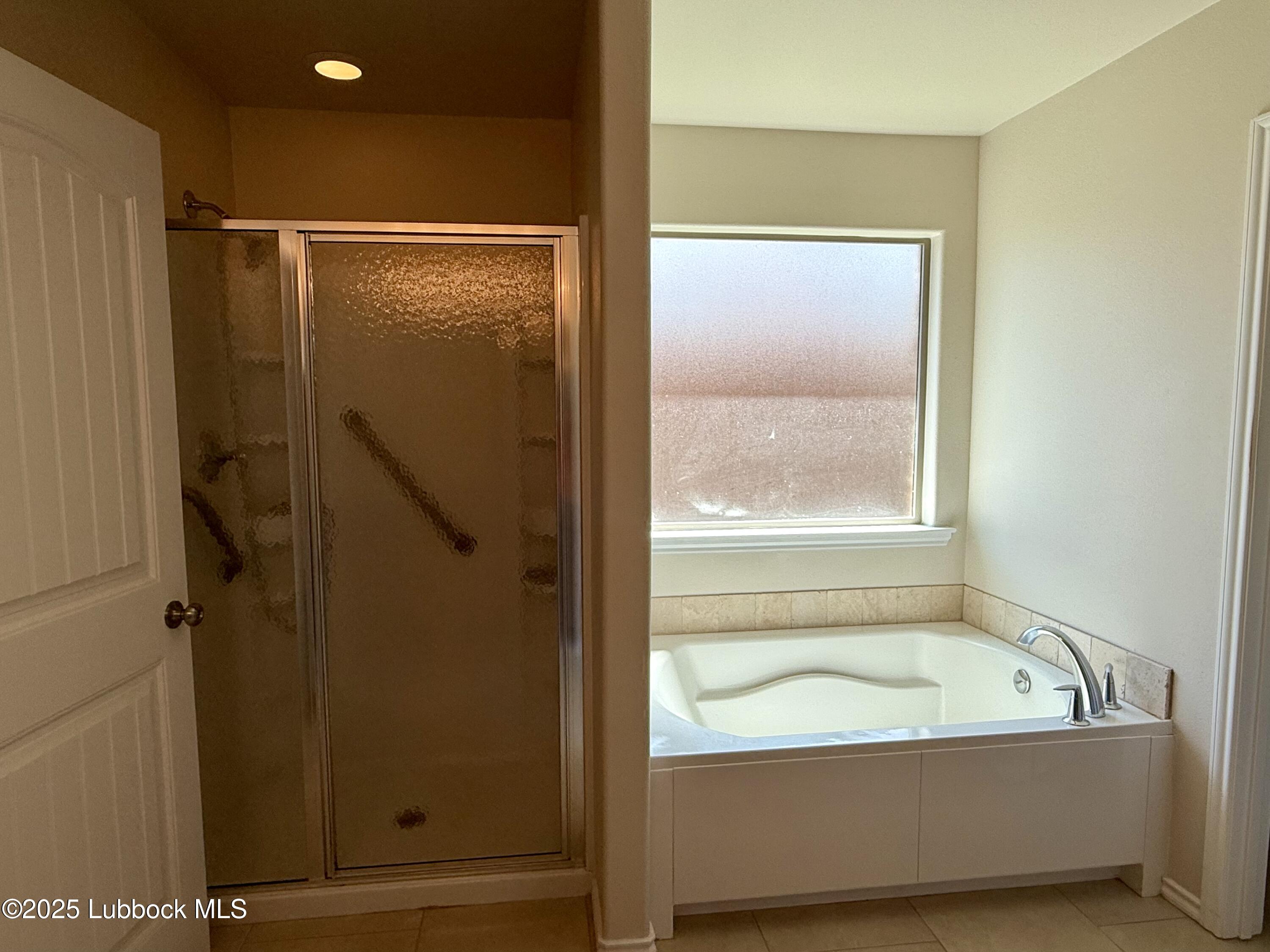 7046 95th Street Lubbock, TX 79424 - Photo 13 of 23 a bathroom with a bathtub and a shower