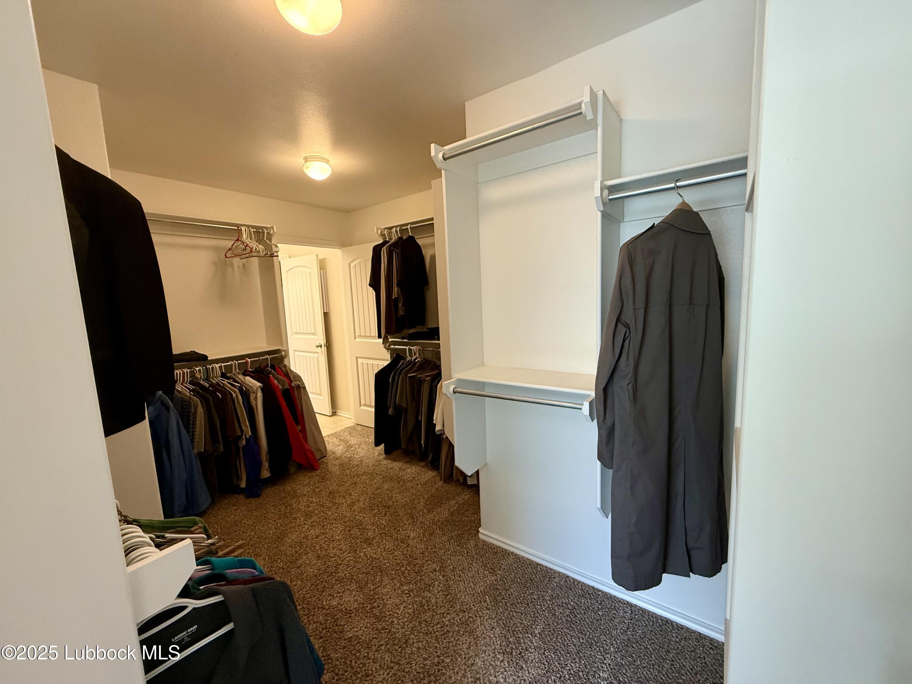 7046 95th Street Lubbock, TX 79424 - Photo 16 of 23 a view of walk in closet with clothes and shoes