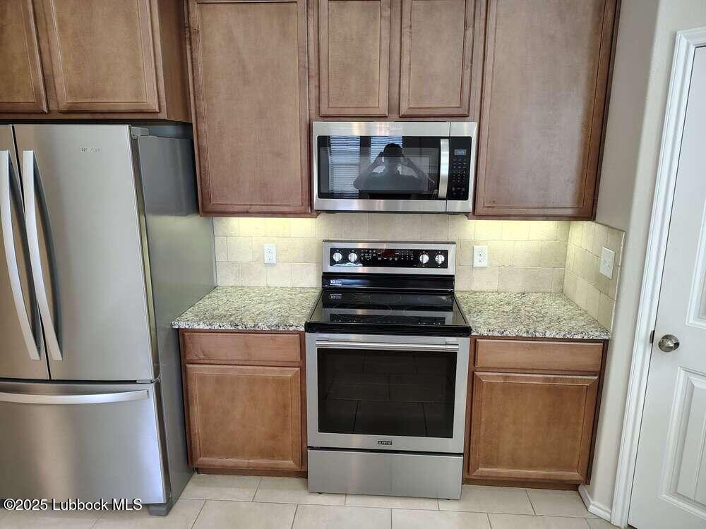 7046 95th Street Lubbock, TX 79424 - Photo 7 of 23 a kitchen with a stove microwave and refrigerator