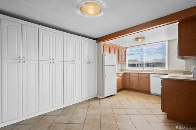 a kitchen with a refrigerator and white cabinets