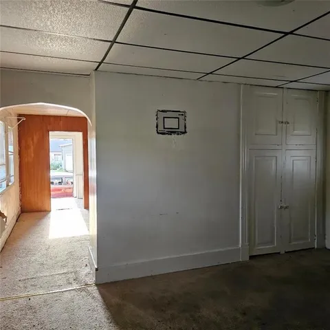 a view of a hallway with wooden floor and a bathroom