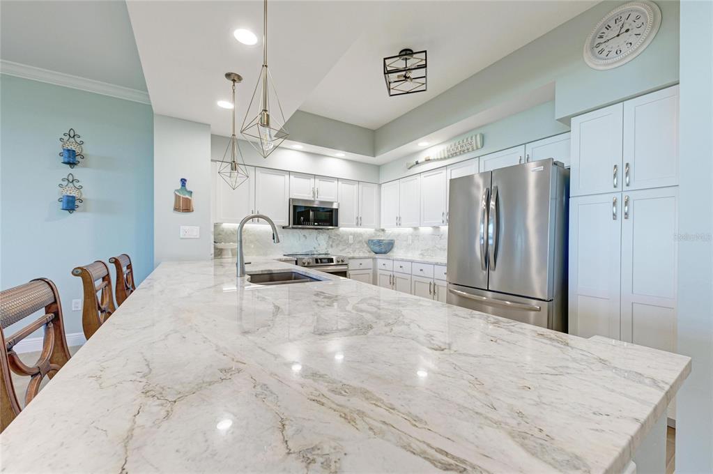3329 Sunset Key Circle, Unit 407 Punta Gorda, FL 33955 - Photo 16 of 68 a large white kitchen with a stove a refrigerator and chandelier