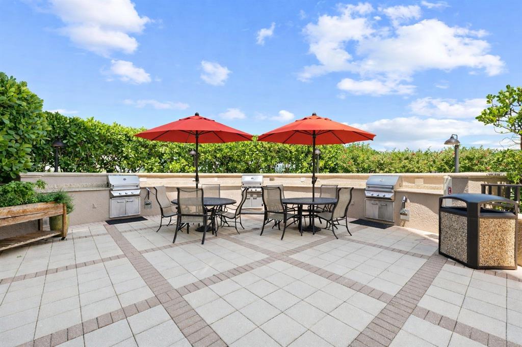 3329 Sunset Key Circle, Unit 407 Punta Gorda, FL 33955 - Photo 47 of 68 a view of a patio with a dining table and chairs under an umbrella