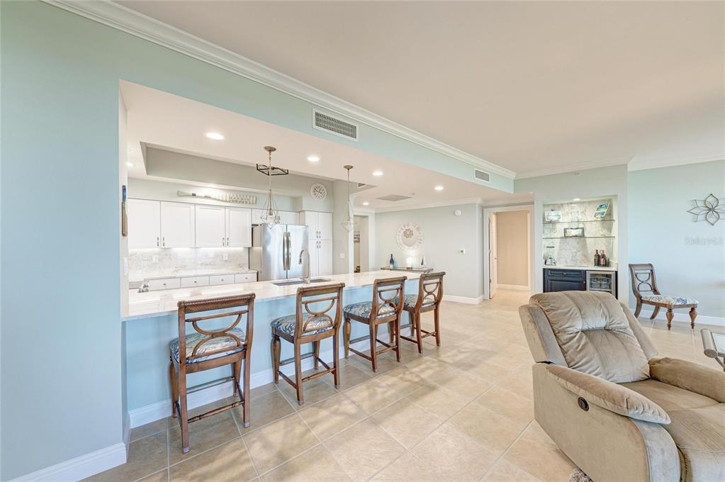 3329 Sunset Key Circle, Unit 407 Punta Gorda, FL 33955 - Photo 10 of 68 a dining hall with stainless steel appliances a dining table and chairs with wooden floor