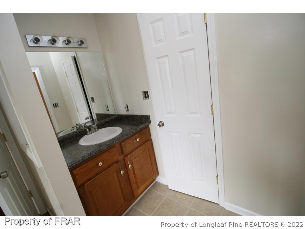 2255 Hackney Loop Fayetteville, NC 28304 - Photo 13 of 36 a bathroom with a sink and mirror