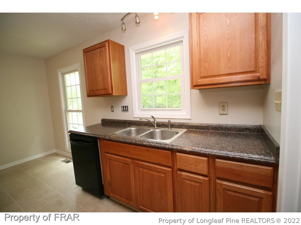2255 Hackney Loop Fayetteville, NC 28304 - Photo 33 of 36 a kitchen with granite countertop cabinets sink and window