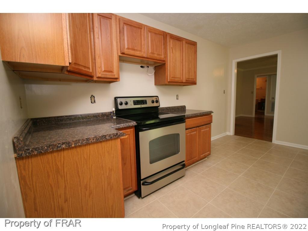 2255 Hackney Loop Fayetteville, NC 28304 - Photo 34 of 36 a kitchen with stainless steel appliances granite countertop a stove a sink and a microwave