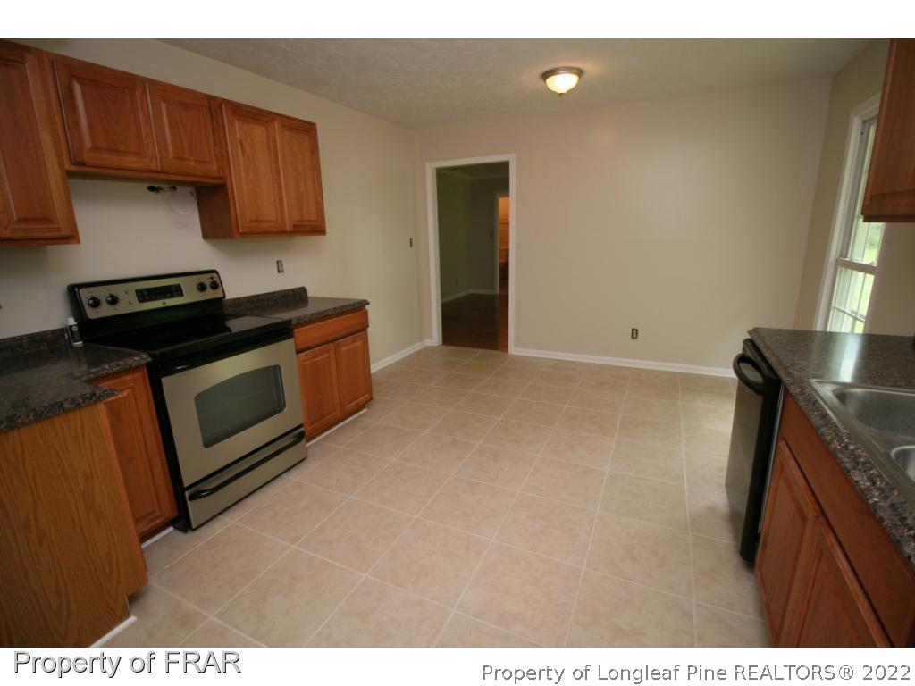 2255 Hackney Loop Fayetteville, NC 28304 - Photo 6 of 36 a kitchen with stainless steel appliances granite countertop a stove a sink and a microwave