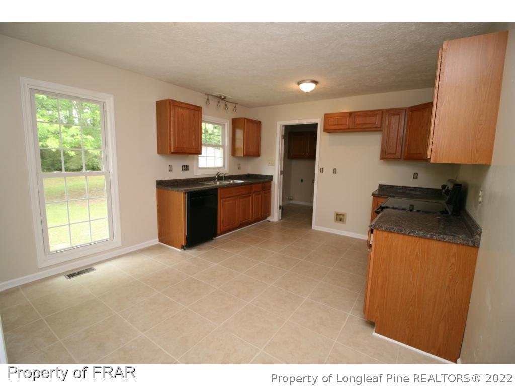 2255 Hackney Loop Fayetteville, NC 28304 - Photo 8 of 36 a kitchen with stainless steel appliances granite countertop a stove a sink a refrigerator and a microwave