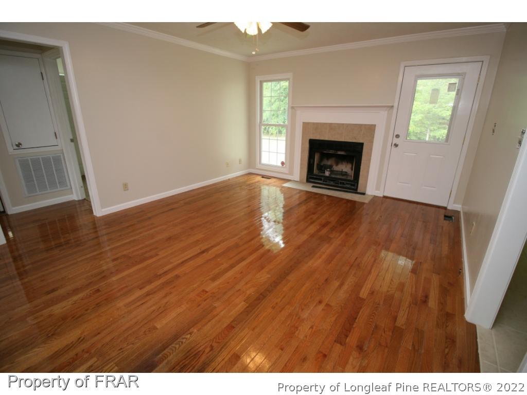 2255 Hackney Loop Fayetteville, NC 28304 - Photo 9 of 36 a view of empty room with wooden floor and fireplace