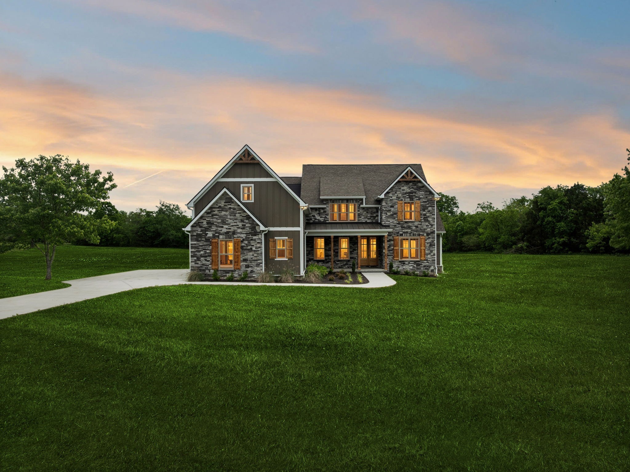 a view of a big house with a big yard and large trees