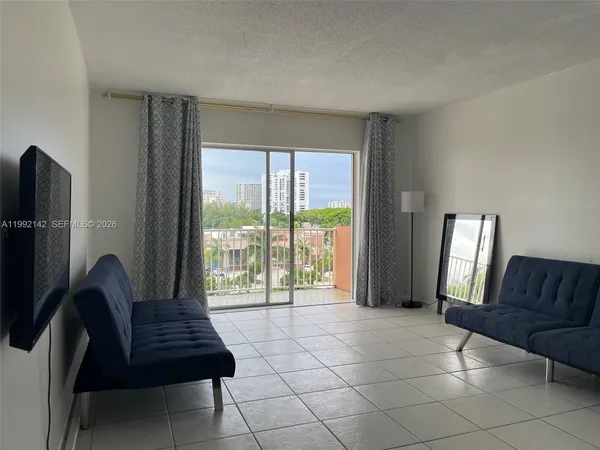 a living room with furniture and a floor to ceiling window