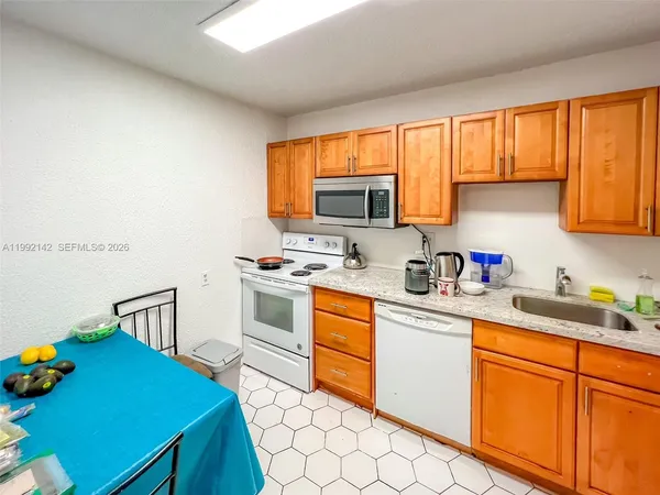 a kitchen with stainless steel appliances granite countertop a sink cabinets and a stove top oven