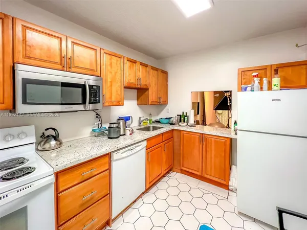 a kitchen with stainless steel appliances granite countertop a refrigerator a stove a sink and a microwave