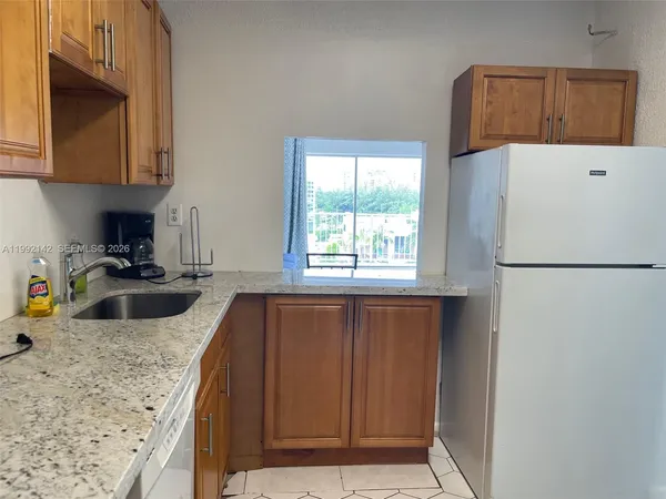 a kitchen with stainless steel appliances granite countertop a refrigerator a sink a stove and dishwasher