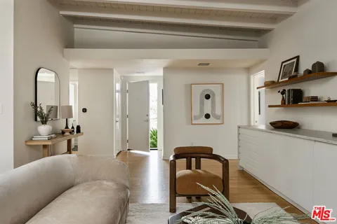 a bedroom with bed and wall painting with wooden floor