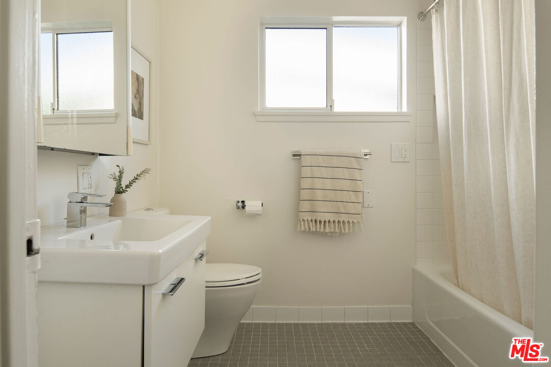 6006 Babbitt Avenue Encino, CA 91316 - Photo 22 of 32 a bathroom with a sink a toilet and a window