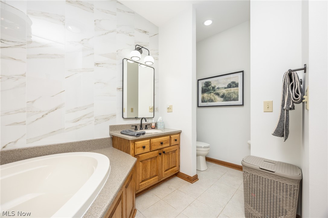 1602 Glendale Road, Unit 3 Marietta, OH 45750 - Photo 22 of 49 Bathroom featuring a built-in soaking tub with a perimeter countertop, wood vanity with a single sink and dark hardware, and a framed mirror above