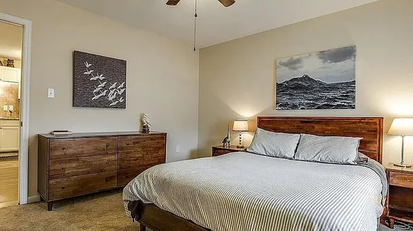 a bedroom with a bed and a painting on the wall