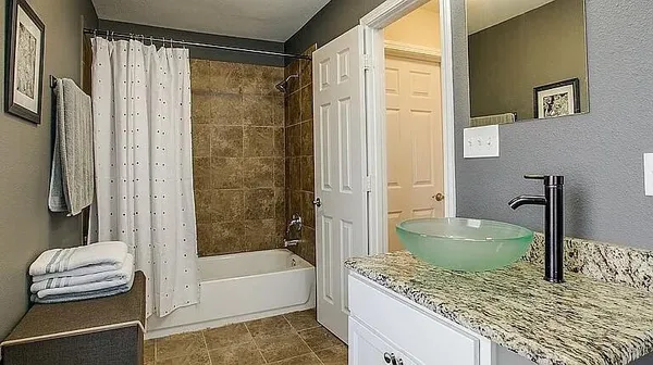 a bathroom with a granite countertop sink a toilet and bathtub