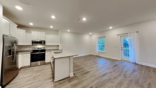 a kitchen with a sink a refrigerator and a stove top oven