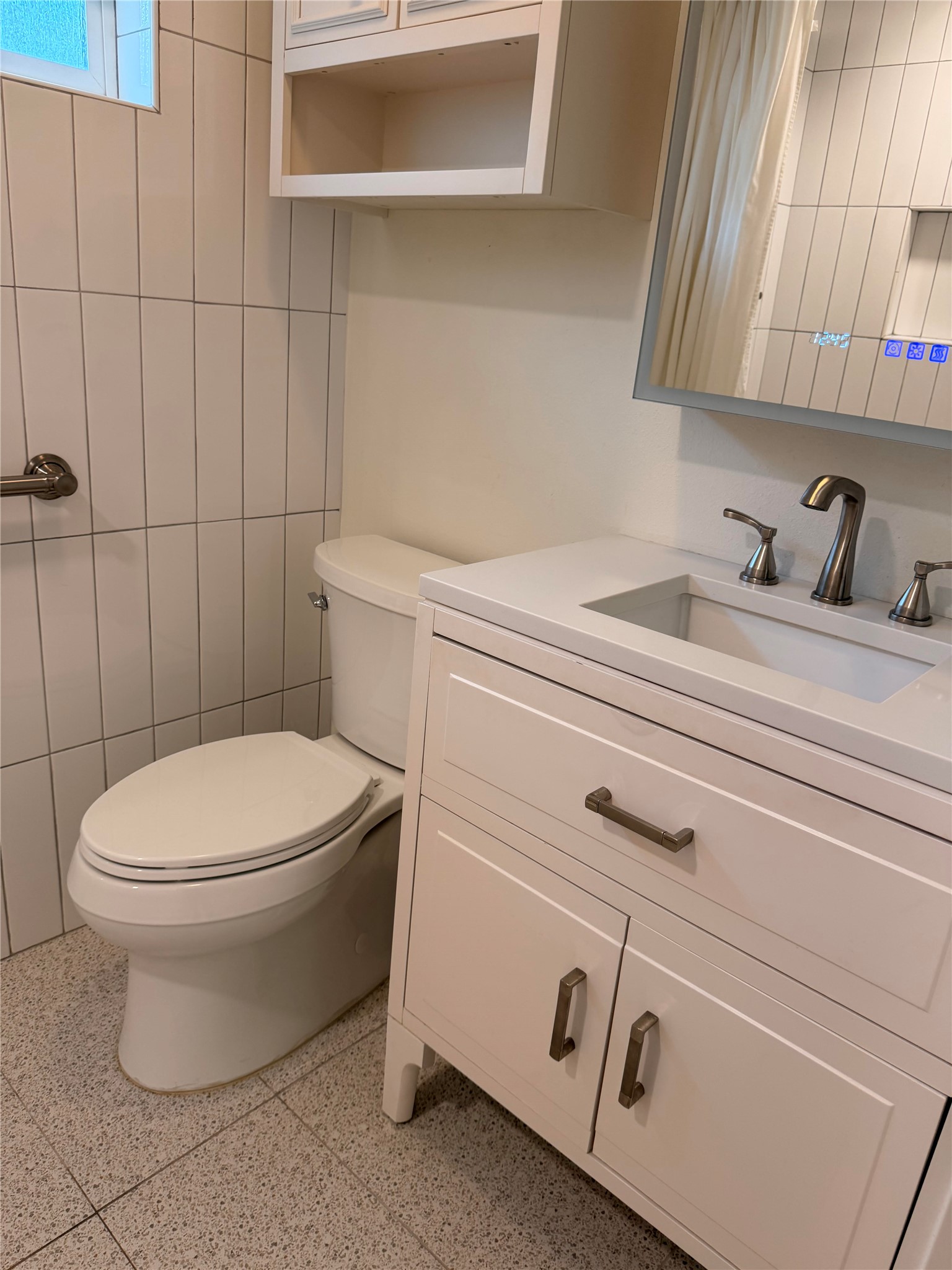 1182 Pandora Street Austin, TX 78702 - Photo 13 of 19 A well-appointed bathroom features a contemporary vanity and pristine white tile finishes.