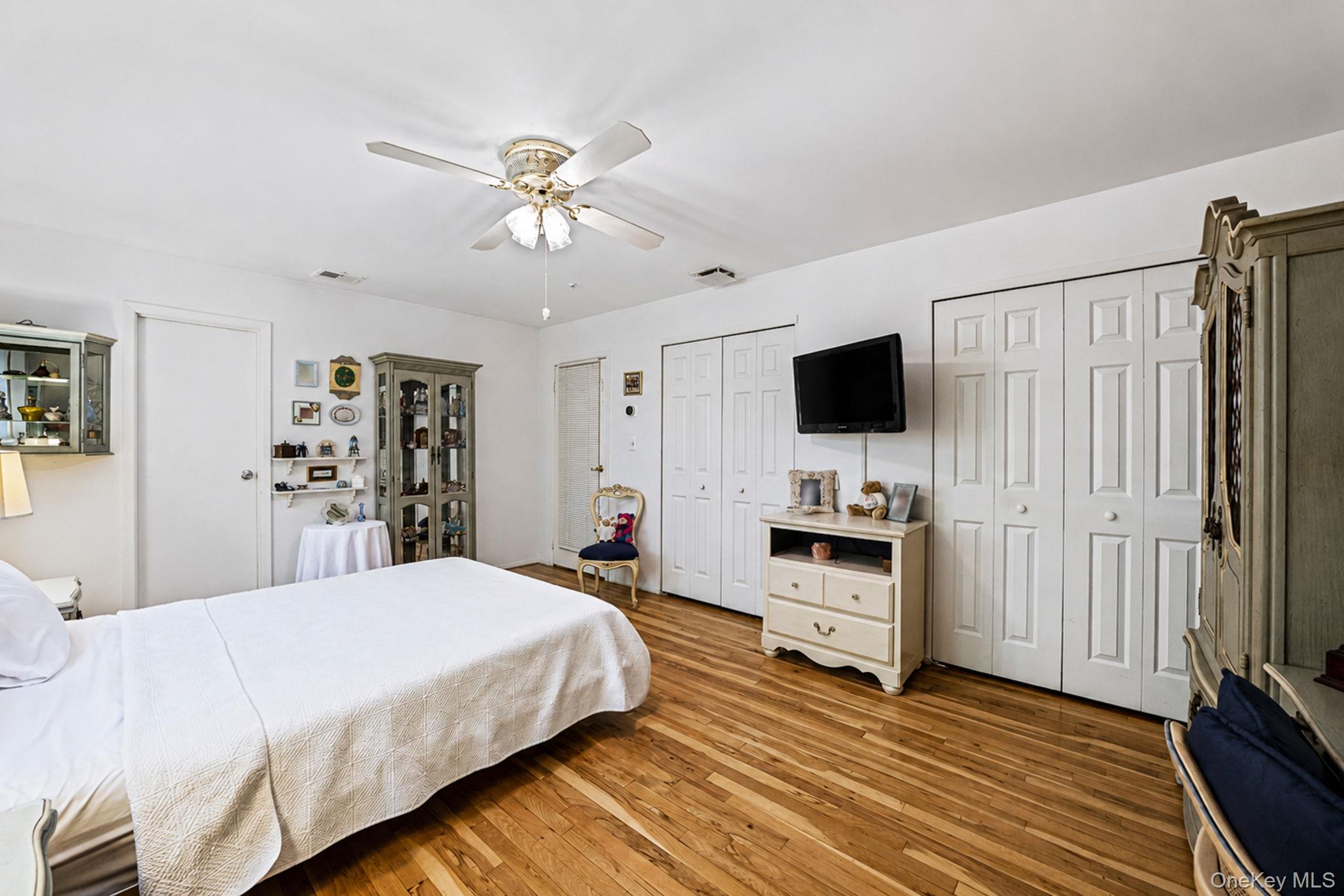 96 Fulton Boulevard Commack, NY 11725 - Photo 38 of 41 a bedroom with a bed and a flat tv screen on the dresser