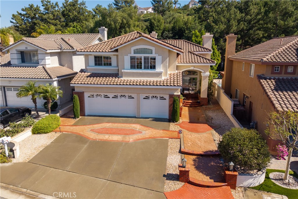 7668 East Hollow Oak Road Anaheim Hills, CA 92808 - Photo 1 of 1 a front view of a house with a garden and trees