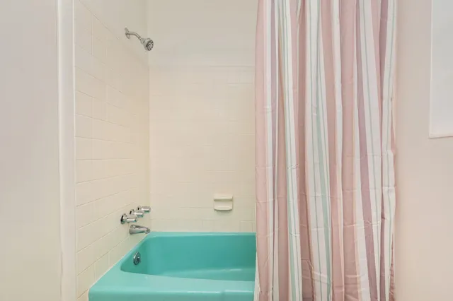 a bathroom with a shower curtain and a window