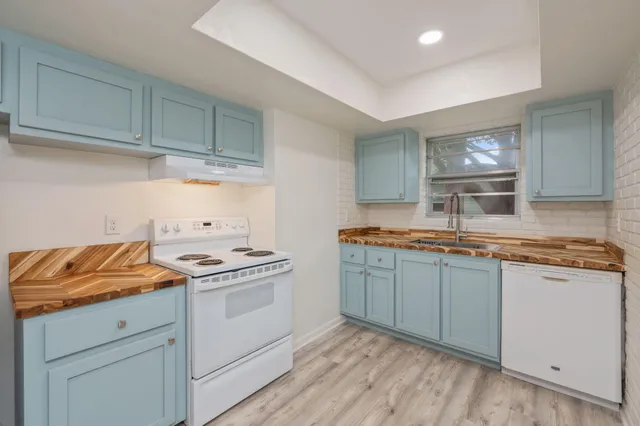 a kitchen with granite countertop cabinets stainless steel appliances and a sink