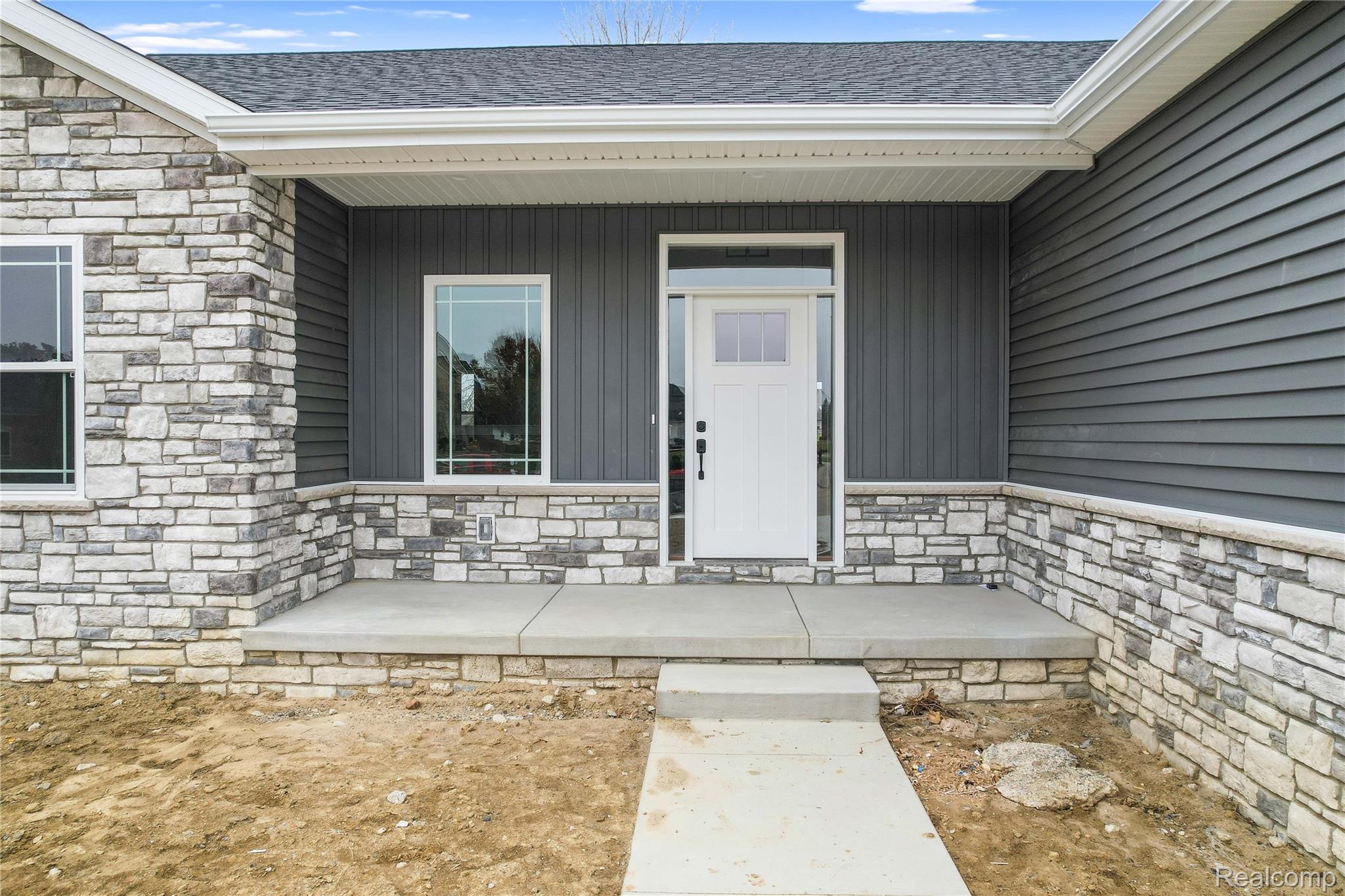 9033 Copper Ridge Drive Davison, MI 48423 - Photo 26 of 29 Doorway to property with stone siding, covered porch, and roof with shingles