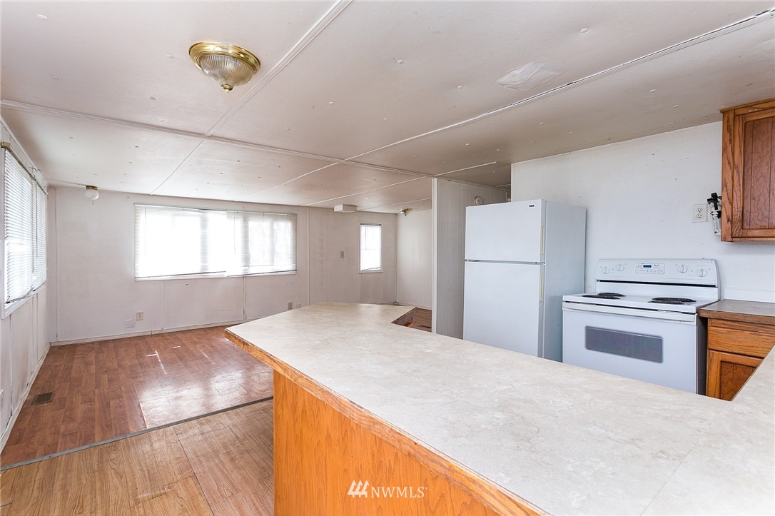 3676 North Red River Road Ferndale, WA 98248 - Photo 7 of 26 a kitchen with refrigerator cabinets and wooden floor