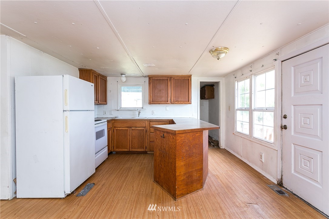 3676 North Red River Road Ferndale, WA 98248 - Photo 8 of 26 a kitchen with a refrigerator a stove top oven and wooden floors