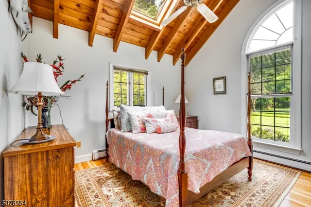 a living room with furniture large window and wooden floor