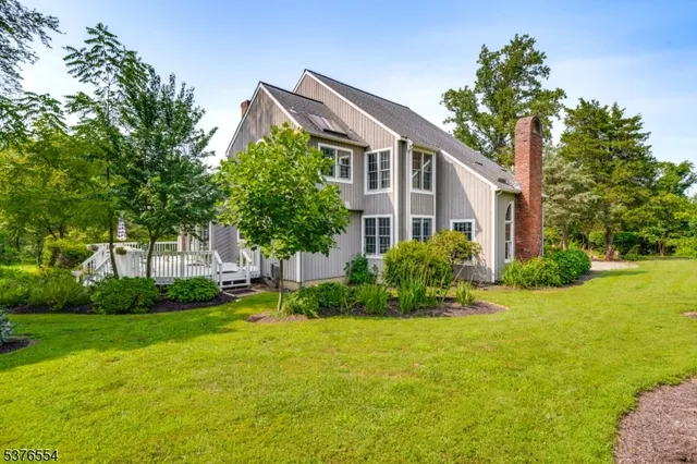 a front view of a house with a yard and trees