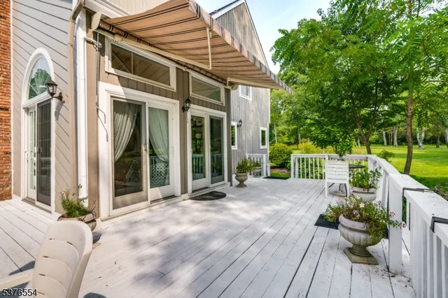a view of a patio with a table and chairs with wooden floor and fence