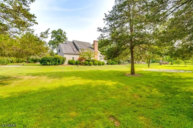 a view of a house with a big yard and palm trees