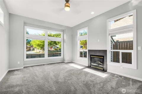 a view of empty room with a fireplace and window