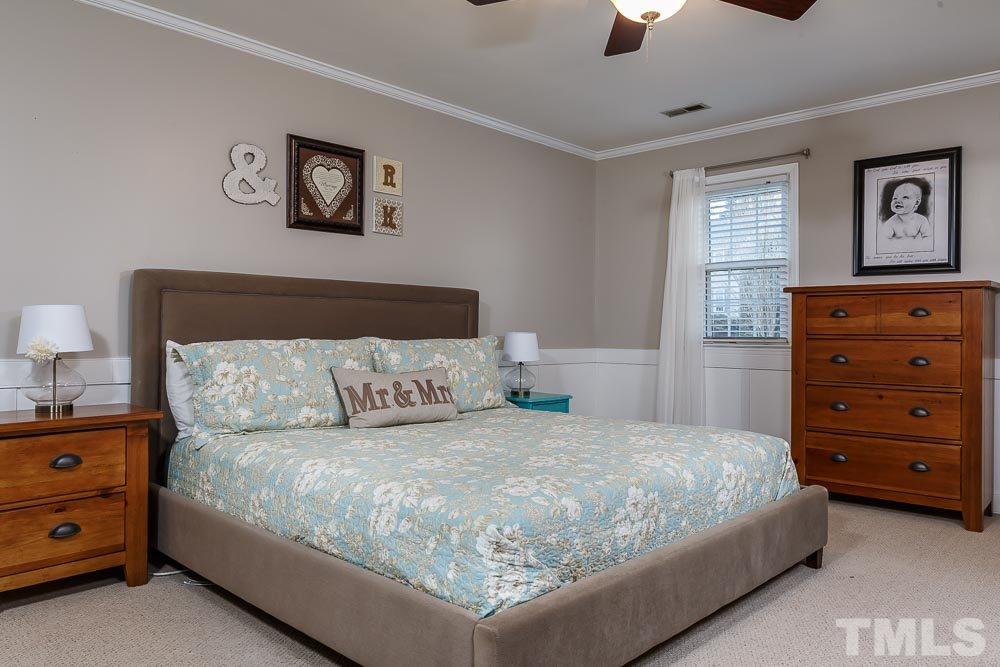 6932 Three Bridges Circle Raleigh, NC 27613 - Photo 12 of 25 a bedroom with a bed and a lamp on dresser