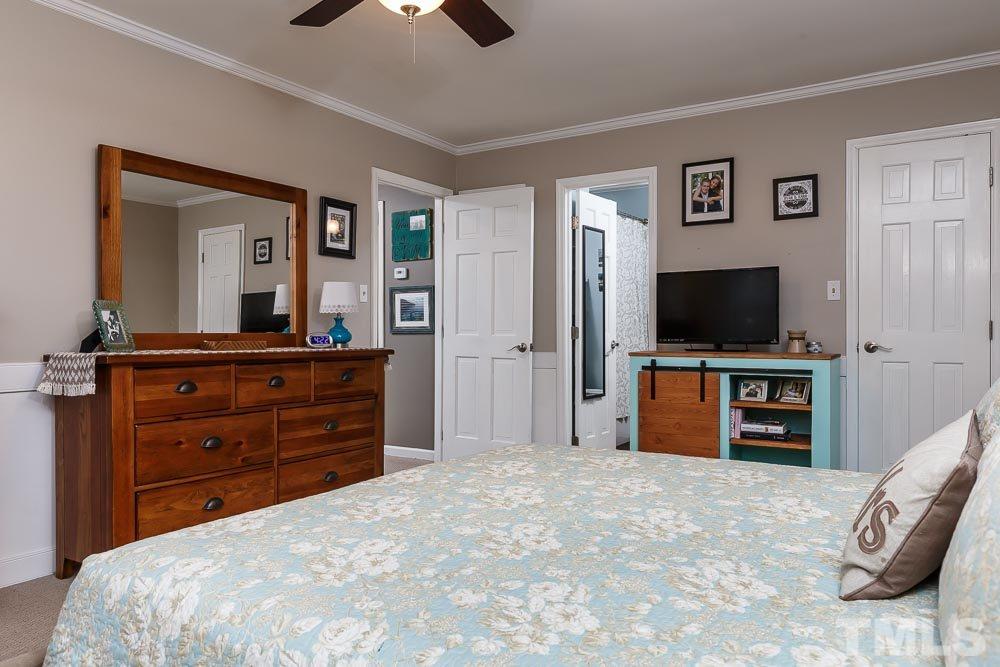 6932 Three Bridges Circle Raleigh, NC 27613 - Photo 13 of 25 a bedroom with a bed and a flat screen tv