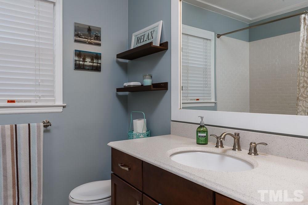 6932 Three Bridges Circle Raleigh, NC 27613 - Photo 14 of 25 a bathroom with a granite countertop sink toilet and mirror