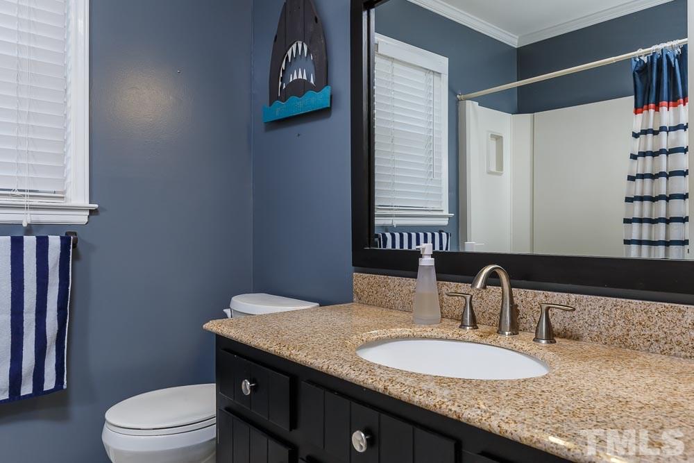 6932 Three Bridges Circle Raleigh, NC 27613 - Photo 20 of 25 a bathroom with a granite countertop sink a toilet and a mirror