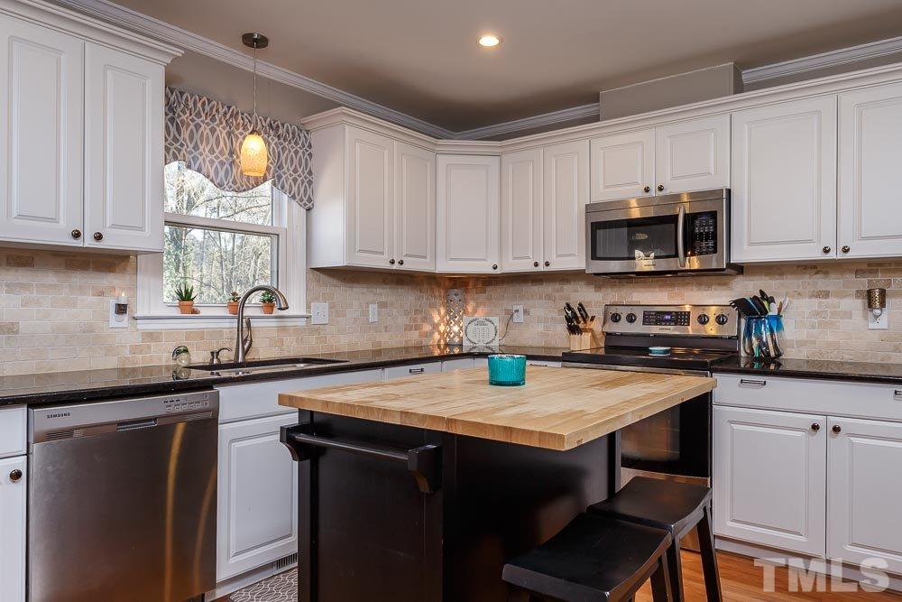6932 Three Bridges Circle Raleigh, NC 27613 - Photo 7 of 25 a kitchen with a sink a microwave and cabinets