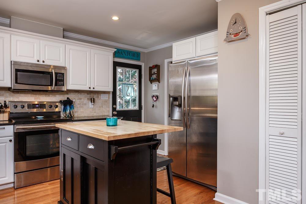 6932 Three Bridges Circle Raleigh, NC 27613 - Photo 8 of 25 a kitchen with a refrigerator stove and microwave