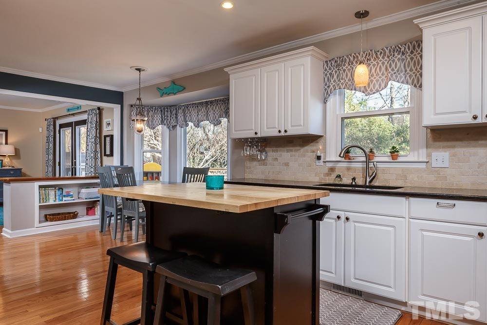 6932 Three Bridges Circle Raleigh, NC 27613 - Photo 9 of 25 a kitchen with stainless steel appliances granite countertop a stove a sink dishwasher and cabinets with wooden floor