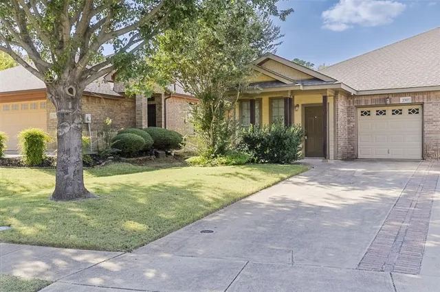 a front view of a house with a yard and potted plants